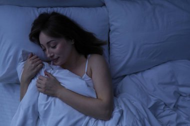 Evdeki yatakta uyuyan güzel bir kadın.