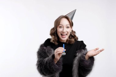 Doğum günü kutlaması. Beyaz arka planda parti kornası çalan kadın.