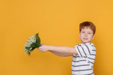 Sarı arka planda vadideki güzel çiçekleri olan çocuk. Metin için boşluk