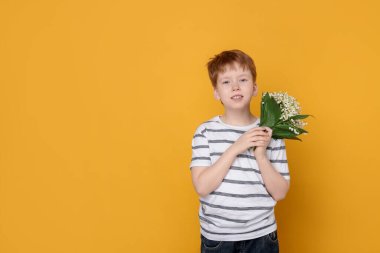Sarı arka planda vadideki güzel çiçekleri olan çocuk. Metin için boşluk