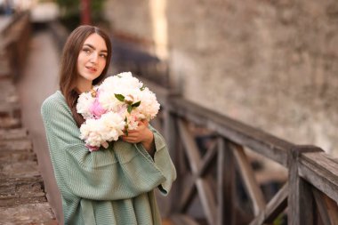 Şehir caddesinde bir buket güzel şakayığı olan çekici bir kadın. Metin için boşluk
