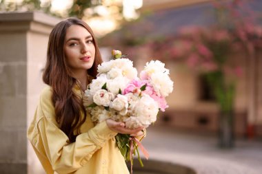 Şehir caddesinde elinde şakayık demeti olan bir kadın. Metin için boşluk