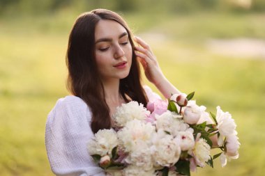 Parkta şakayık demeti olan güzel bir kadın.