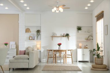 Odada rahat bir kanepe ve sandalyeli şık bir yemek masası. İç tasarım