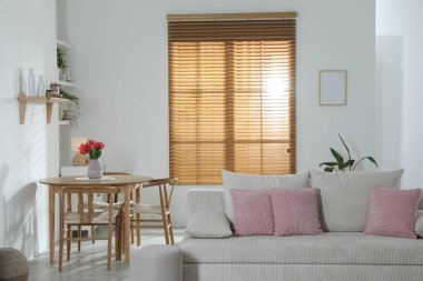 Odada rahat bir kanepe ve sandalyeli şık bir yemek masası. İç tasarım