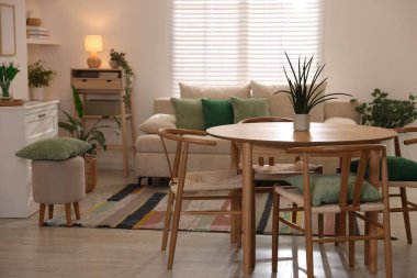 Odada rahat bir kanepe ve sandalyeli şık bir yemek masası. İç tasarım