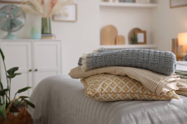 Odasında yumuşak çarşaflar ve battaniyeler olan rahat bir yatak, yakın plan. Ev tekstili