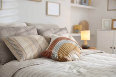 Odasında yumuşak çarşaflar olan rahat bir yatak, yakın çekim. Ev tekstili