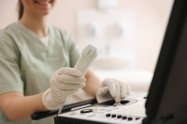 Klinikte ultrason makinesi olan profesyonel sonograf, yakın plan.