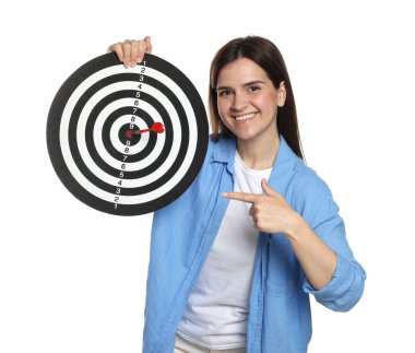 Hedef alınıyor. Gülen kadın beyaz arka planda oku olan dart tahtasına işaret ediyor.