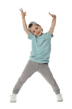 Beyzbol şapkalı küçük mutlu çocuk beyaz arka planda dans ediyor.