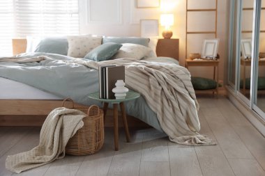 Yumuşak çarşafları, lambası ve dekoru olan rahat bir yatak. Ev tekstili