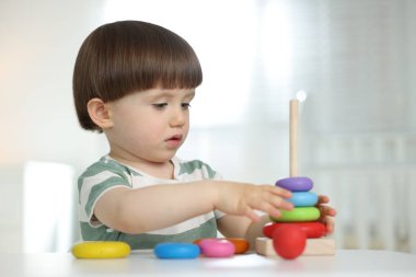 Masada oyuncak piramidiyle oynayan sevimli küçük çocuk.