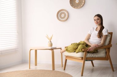 Evdeki rahat koltukta dinlenen güzel kadın.