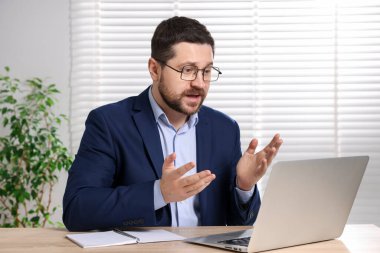 İçerideki masada dizüstü bilgisayarı olan internet hoparlörü.