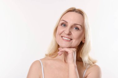 Beyaz arka planda gülümseyen orta yaşlı kadın portresi. Metin için boşluk