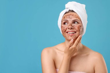 Yüzünde açık mavi bir arka plan olan gülümseyen bir kadın. Metin için boşluk