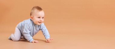 Bej arka planda emekleyen şirin küçük bebek, mesaj için yer