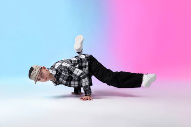 Renkli arka planda dans eden şık elbiseli çocuk.