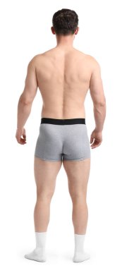 Beyaz arka planda açık gri iç çamaşırlı genç adam.