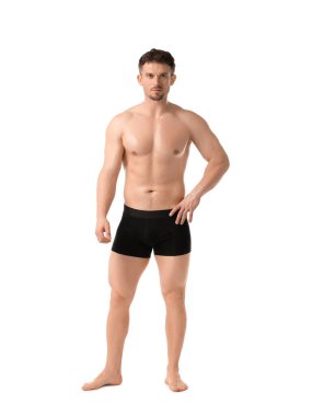 Beyaz arka planda siyah iç çamaşırlı genç adam.