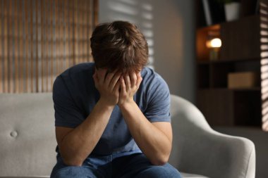 Gençlik sorunları. Evdeki kanepede depresif bir genç çocuk.