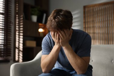 Gençlik sorunları. Evdeki kanepede depresif bir genç çocuk.