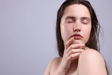 Gri arka planda doğal ten rengi olan güzel bir kadın. Yakın plan. Metin için boşluk