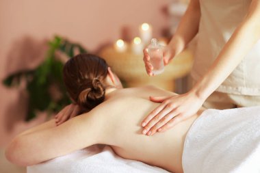Spa salonunda kadın sırt masajı yaptırıyor.