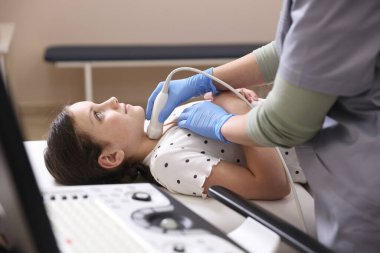 Sonograf, klinikte kızın tiroid bezi ultrason muayenesini yönetiyor.