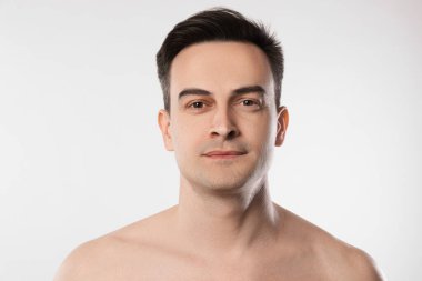 Açık gri arka planda yakışıklı bir adamın portresi, yakın plan.