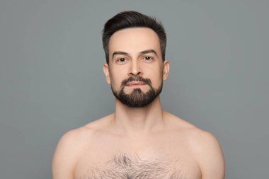 Gri arka planda tıraş olmadan önce yakışıklı bir adam.