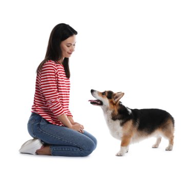 Mutlu kadın köpeğini beyaz arka planda eğitiyor.