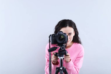 Açık gri arkaplanda profesyonel video kamerası olan kadın, metin için boşluk