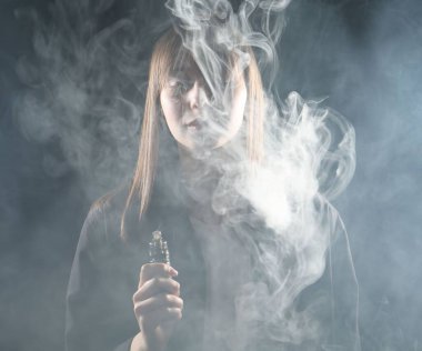 Esmer arkaplanda elektronik sigara içen kadın