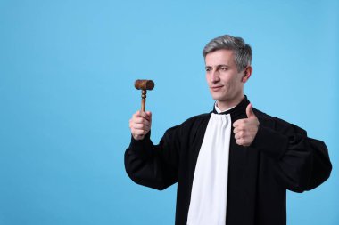 Elinde sopası olan yargıç açık mavi arka planda onaylıyor. Metin için boşluk