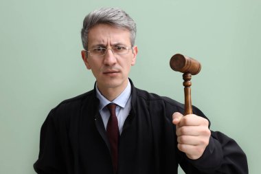 Yeşil arka planda tokmağı olan duygusal yargıç.