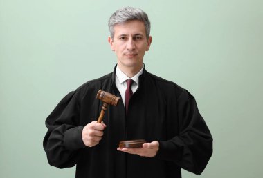 Yeşil arkaplanda çekiç ve ses engeli olan yargıç