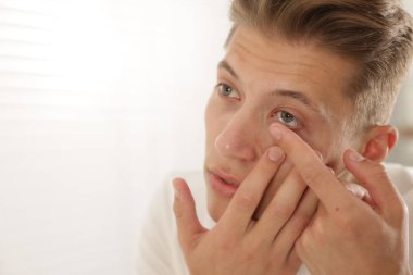 Adam eve kontak lens takıyor, yakın çekim. Metin için boşluk