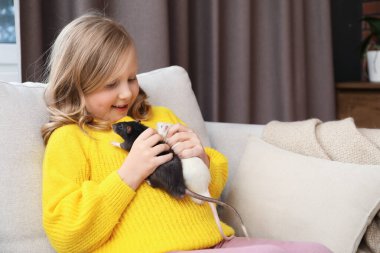 Evdeki kanepesinde şirin fareler olan küçük kız, mesaj atmak için yer var.