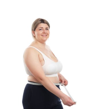 Kilo kaybı. Artı, beyaz arka planda bantla bel ölçüsü ölçen bir kadın.