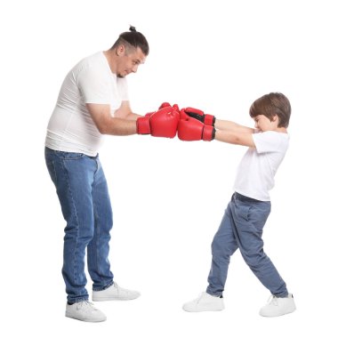 Babası ve oğlu beyaz arka planda boks yapıyor.