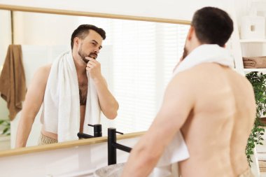 Banyoda aynaya bakmadan önce yakışıklı bir adam.