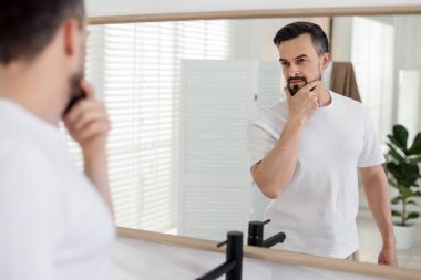 Banyoda aynaya bakmadan önce yakışıklı bir adam.