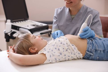 Sonograf, klinikte küçük bir kızın karın ultrasonu muayenesi yapıyor.