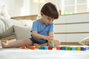 Evde renkli küpleri ile oynayan sevimli küçük çocuk