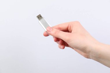 Açık gri arka planda modern flash diski olan adam, yakın plan. Metin için boşluk