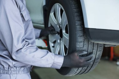 Tamirci araba servisinde lastik değiştiriyor, yakın plan.