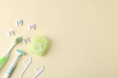 Bej arka planda farklı oral bakım ürünleri ve diş modelleri var. Metin için boşluk