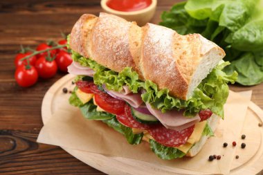 Tahta masada jambonlu ve sebzeli baget sandviç, yakın plan.